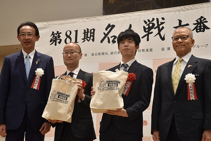 The 81st Meijin Seventh Game, Round 3: The day before the game Meijin Akira Watanabe  second from left  and Osho Sota Fujii  third from left  hold souvenirs of the city mascot character  Hanitan  at the eve of the 3rd game of the 81st Meijin Tournament at Hotel Abest Grande Takatsuki in Takatsuki City, May 12, 2023, 6:35 p.m. Photo by Haruno Kosaka