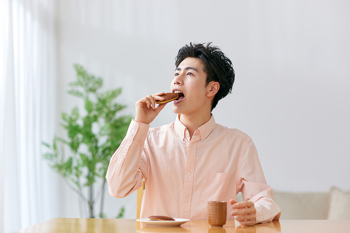 Young Japanese man eating dorayaki