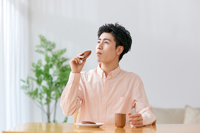 Young Japanese man eating dorayaki