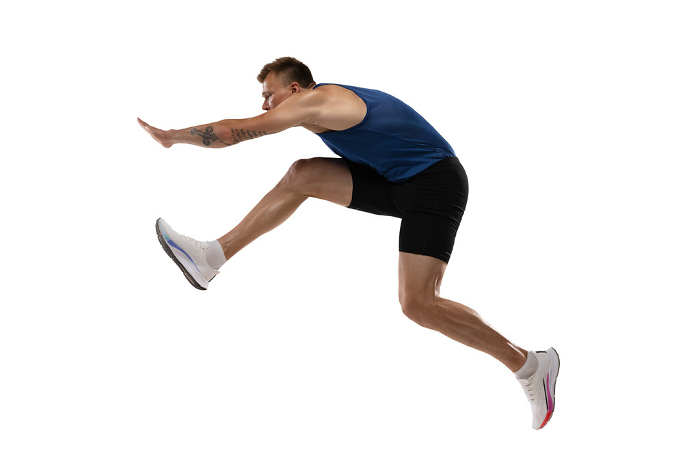 Athlete man athlete jumps over the barrier isolated on white background. Caucasian professional male athlete jumping over the barrier isolated on white background. Running with obstacles concept. Muscular man. Action, motion, healthy, sport and lifestyle. Copyspace for ad.
