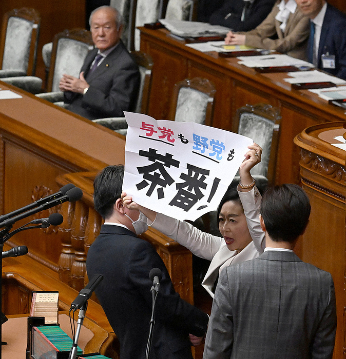 Plenary Session of the Diet, House of Representatives Banri Kushibuchi  front right , co chairman of the Reiwa Shinsengumi, holds up a paper while voting for a no confidence motion against Finance Minister Shunichi Suzuki  back left  at a plenary session of the House of Representatives, 2:25 p.m., May 18, 2023, in the National Diet  photo by Mikaru Takeuchi.