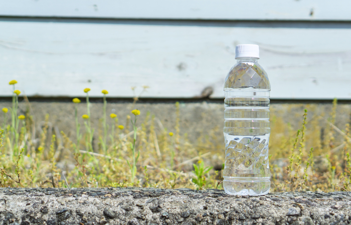 Plastic bottles of water and copy space on the side of the road