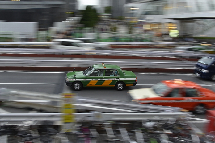 Cab Industry Oversupplied Government to Tighten Regulations October 23rd, 2013 : A taxi passes in front of Shinjuku Station, Shinjuku, Tokyo, Japan on October 23, 2013. The number of taxis has been increasing since 2002 when a regulation on taxis was loosened, and the Liberal Democratic Party tries to re regulate the number of taxis during this extraordinary session of the diet.  Photo by Koichiro Suzuki AFLO 