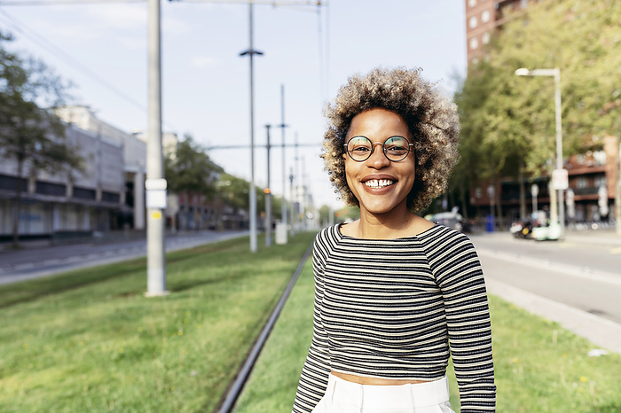 Portrait of Afro-American woman posing in the street with white pants