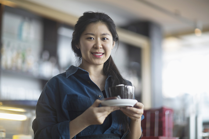 Young Woman, asia,  Portrait of a young waitress serving coffee in coffee shop, Freiburg Im Breisgau, Baden winterttemberg, Germany