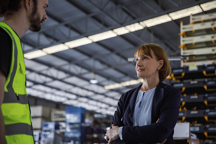 Mature manager talking with colleague at warehouse