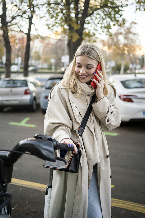 gen z girl using eco friendly transportation Madrid Spain Smiling woman talking on smart phone standing at bicycle parking station
