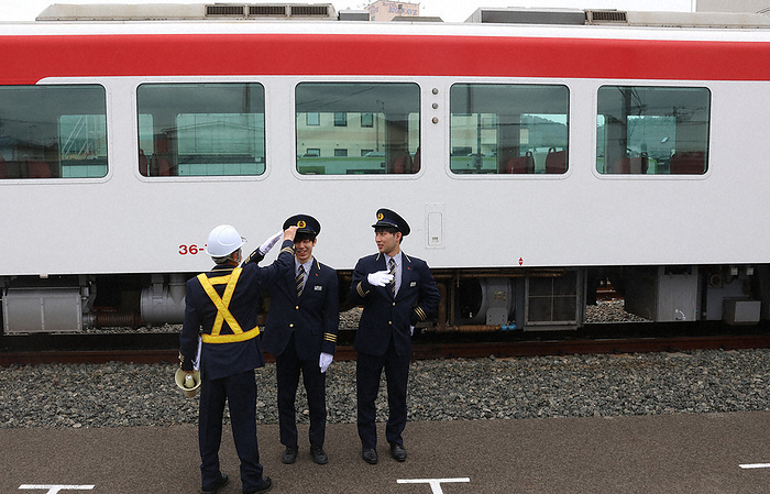 Rokkan Fujii and others become stationmaster for a day at Sanriku Railway Sota Fujii 6 kan  center  and Reo Koyama 4 dan  right  take a commemorative photo in front of a Sanriku Railway train car after being taught how to salute by a staff member.