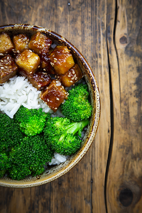 Bowl of coconut rice with tofu, broccoli and sesame seeds