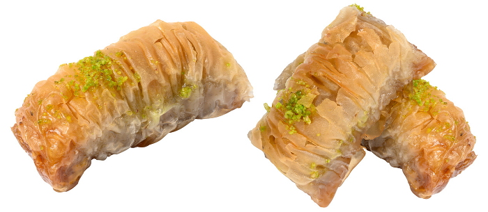 Pieces of baked baklava in honey on a white isolated background. Set Pieces of baked baklava in honey on a white isolated background. Set