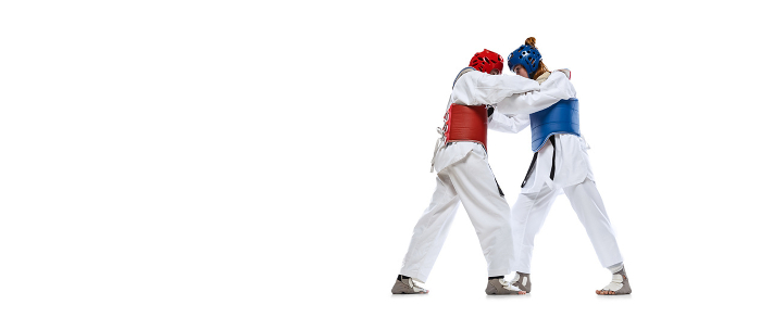 Portrait of two young women, taekwondo athletes practicing, fighting isolated over white background. Concept of sport, skills Sparring. Portrait of two young women, taekwondo athletes practicing, fighting isolated over white background. Concept of sport, education, skills, workout, health. Sportsmen wearing doboks