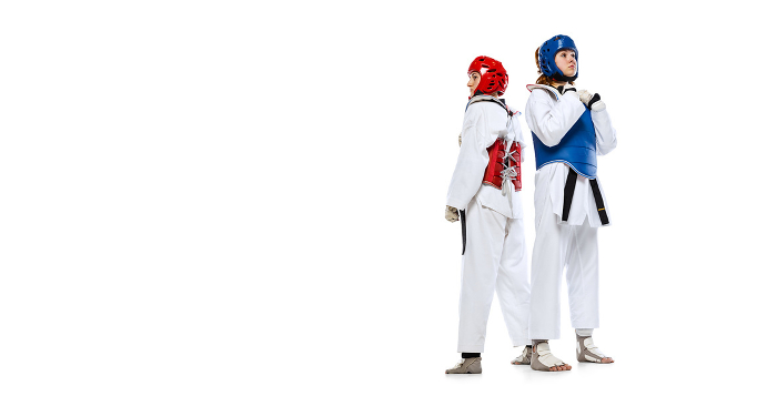 Studio shot of of two young women, taekwondo athletes practicing together isolated over white background. Concept of sport, skills Before fight. Studio shot of of two young women, taekwondo athletes practicing together isolated over white background. Concept of sport, skills. Concept of sport, education, skills, workout, health