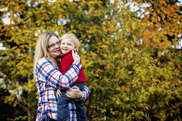 Outdoor portrait of a mother holding young son close, in a park area in autumn; Edmonton, Alberta, Canada, by LJM Photo / Design Pics