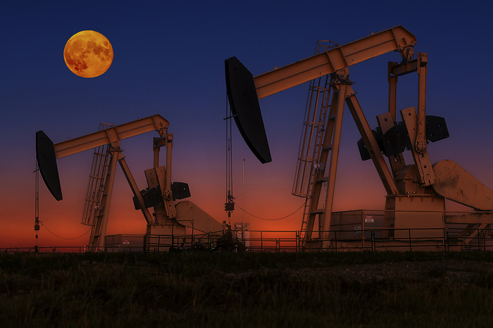 Canada Glowing colourful pumpjacks at sunrise with glowing sky and full moon in the background, West of Airdrie  Alberta, Canada, by Michael Interisano   Design Pics