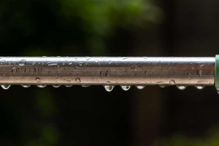 Rainwater dripping from a steel rod
