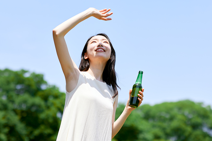 Japanese woman drinking beer with fresh greenery