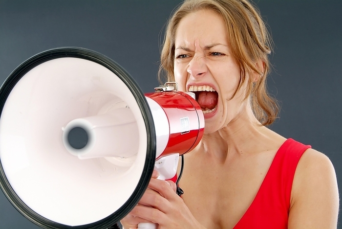 Young woman screaming in a megaphone, by Michaela Begsteiger