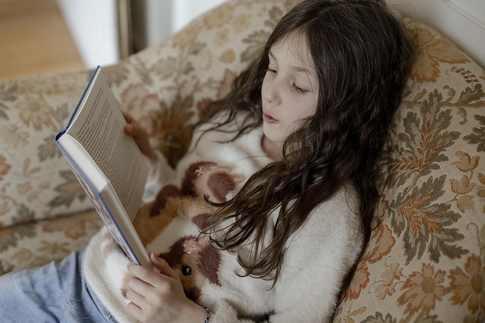 Girl, 8 years, reading a children's book, by Michaela Begsteiger
