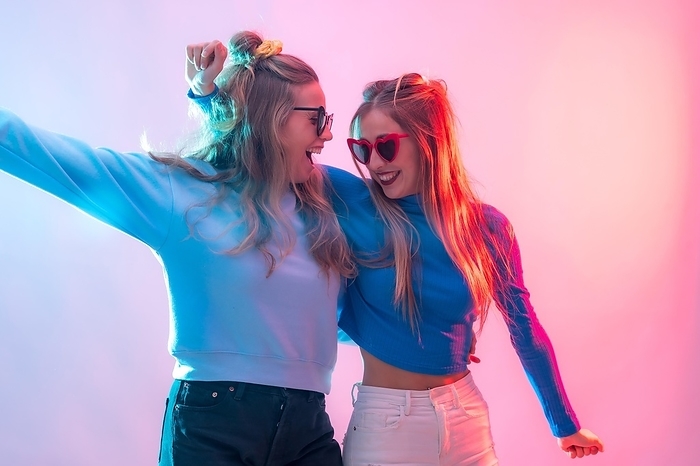 Two young blonde caucasian women dancing in disco, smiling and having fun at party, by Unai Huizi