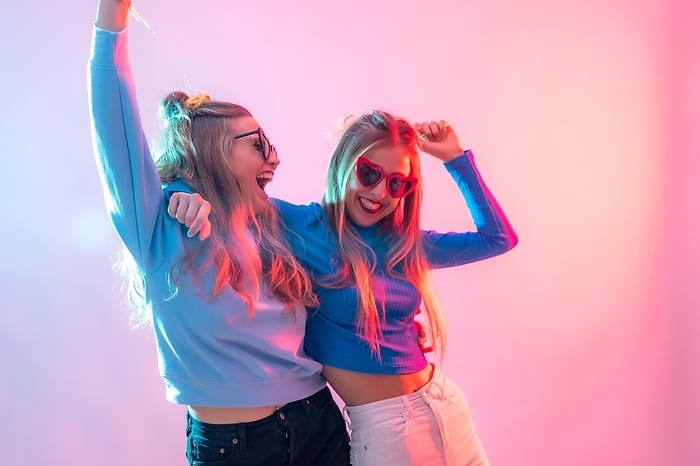 Two young blonde caucasian women dancing in disco, smiling and having fun at party, by Unai Huizi