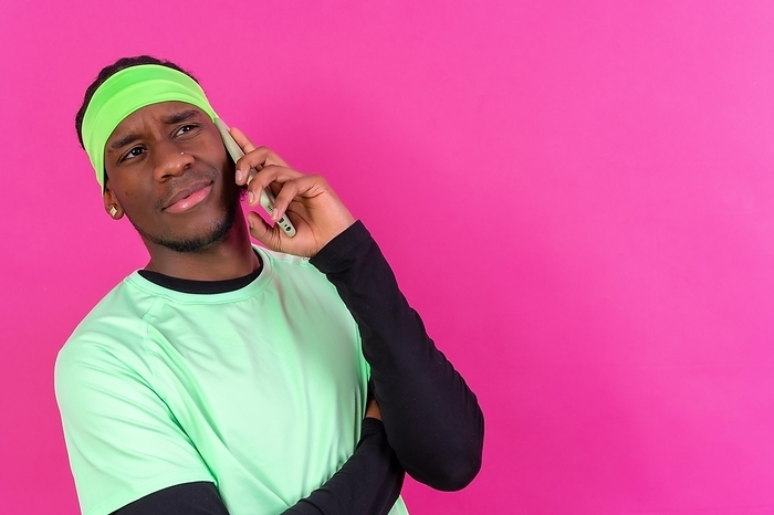 Black ethnic man with a phone in green clothes on a pink background, serious talking on the phone, by Unai Huizi