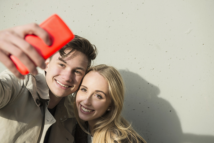 Young couple making a selfy with a smartphone Young couple taking a selfie with smart phone, Munich, Bavaria, Germany