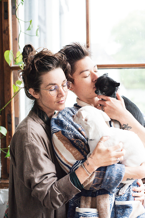 queer couple at home gently cuddling their two chihuahuas
