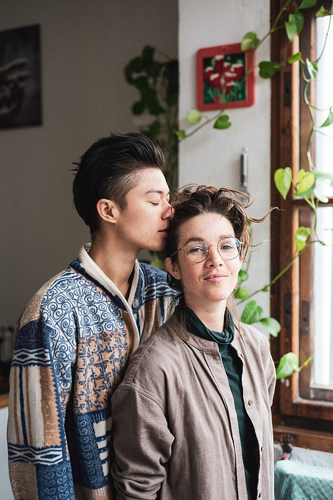 soft romantic moment of queer couple at home with plants