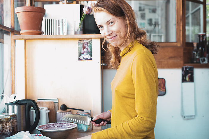 beautiful woman preparing food at home smiles in window light