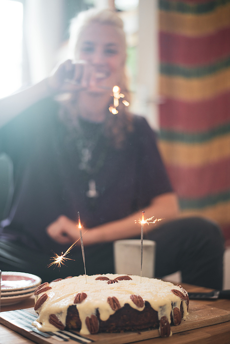 Young woman in Berlin celebrates birthday with sparklers and cake