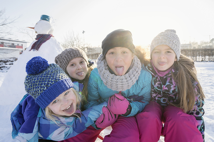 group of girls watching in camera in winter, Portrait of children sticking out tongue
