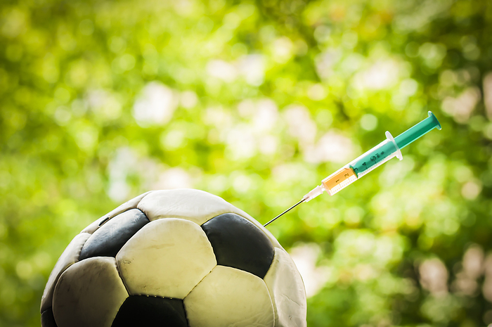 Soccer ball gets an injection with a syringe, doping in sports. Soccer ball gets an injection with a syringe, doping in sports., by Zoonar Uwe Bauch