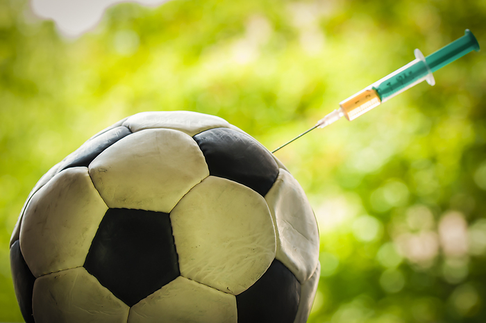 Soccer ball gets an injection with a syringe, doping in sports. Soccer ball gets an injection with a syringe, doping in sports., by Zoonar Uwe Bauch