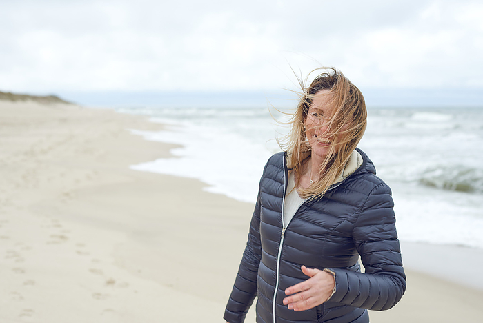 Smiling woman on a windy deserted beach Smiling woman on a windy deserted beach, by Zoonar Lars Zahner