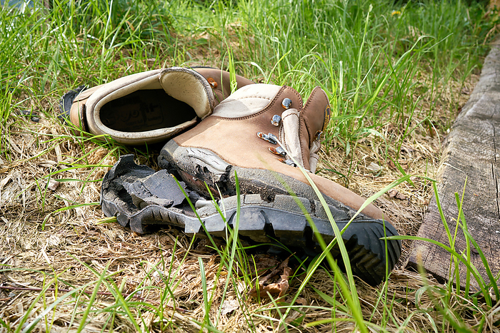 broken hiking boots on a hiking trail broken hiking boots on a hiking trail, by Zoonar Heiko Kueverl