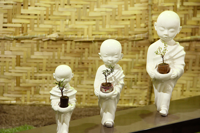 Small Buddha statues holding Bonsai Trees, Bonsai tree exhibition, Pune Small Buddha statues holding Bonsai Trees, Bonsai tree exhibition, Pune, by Zoonar RealityImages