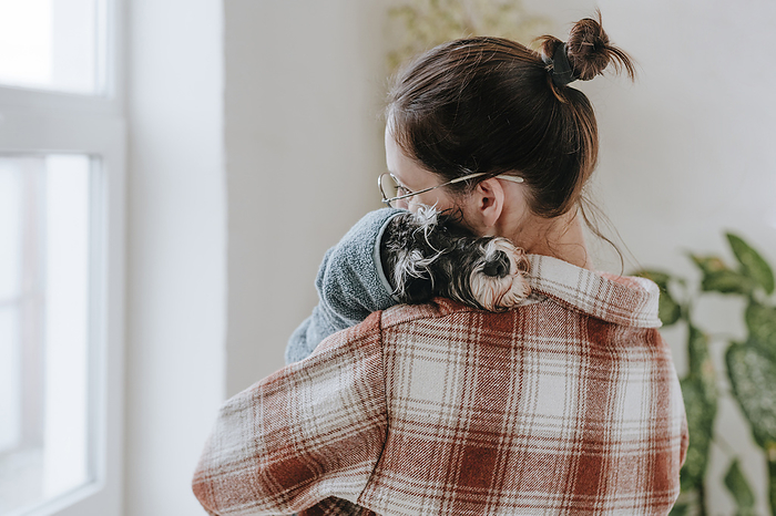 Woman embracing dog after giving bath at home