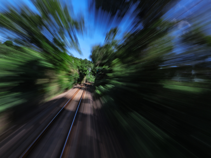 View from a train speeding through a summer field