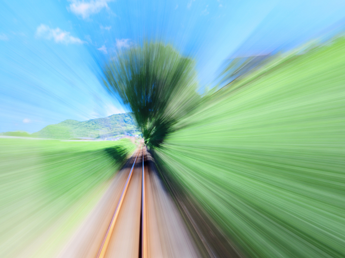 View from a train speeding through a summer field