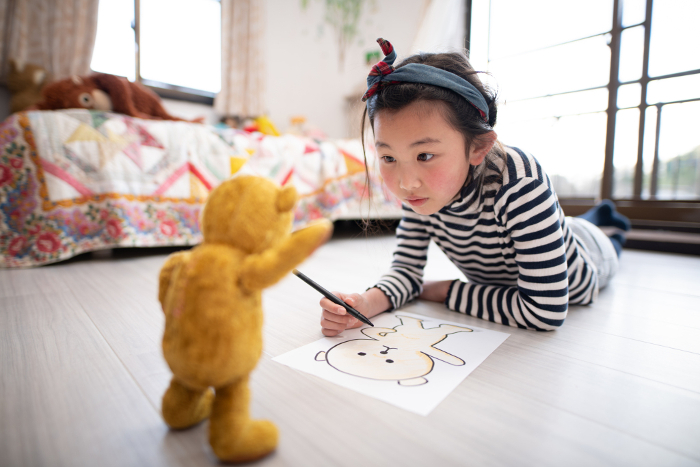 Girl illustrating a bear sewing package.
