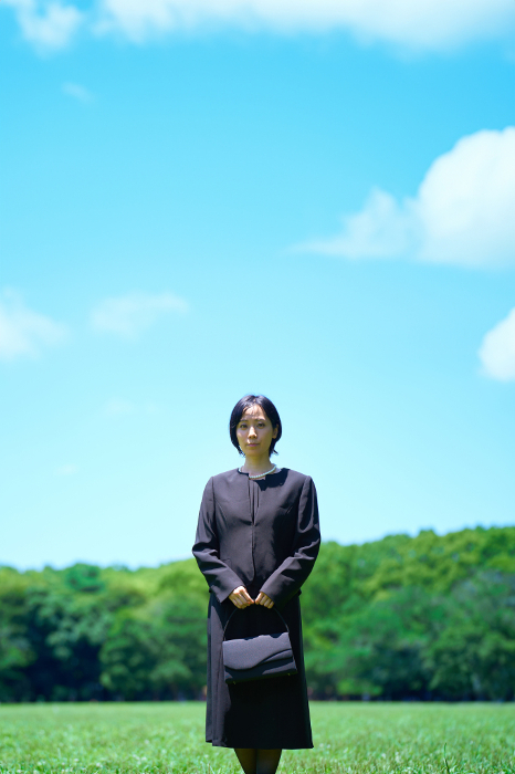 Japanese woman in mourning standing in a green field (People)