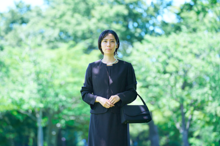 Japanese woman in mourning standing in a green field (People)