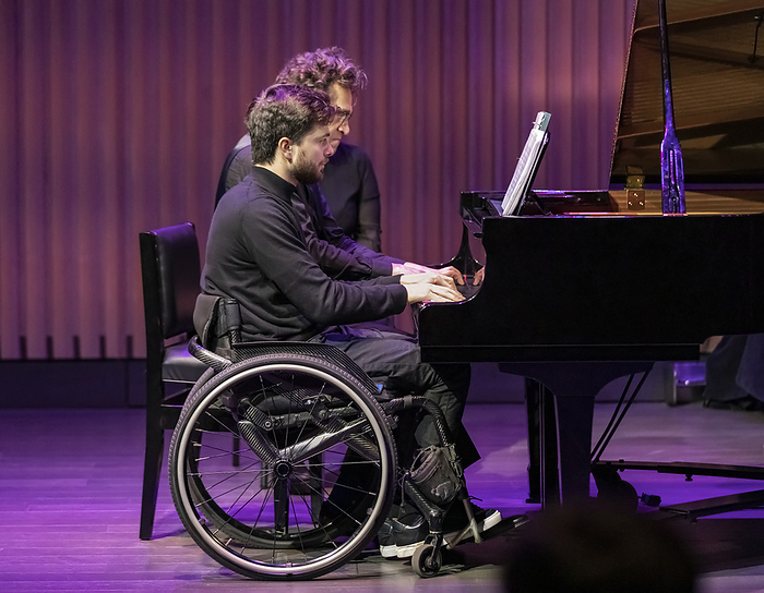 One able-bodied concert pianist performing with a another pianist who has a spinal cord injury; Edmonton, Alberta, Canada, by LJM Photo / Design Pics