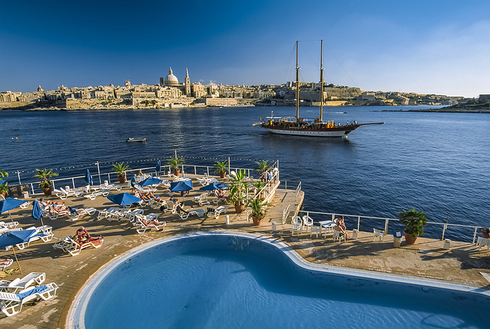 Malta Valletta Two masted schooner in Valletta harbor, Malta, with a swimming pool and sunbathers in the foreground  Valletta, Malta Island, Malta, by Michael Melford   Design Pics