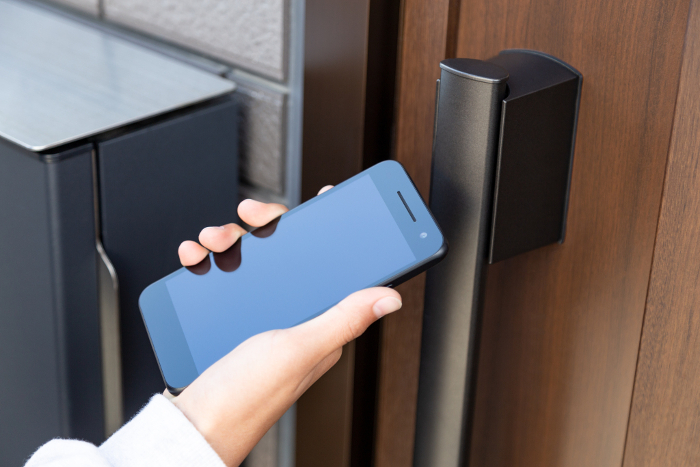 Hand to unlock the front door with a smartphone