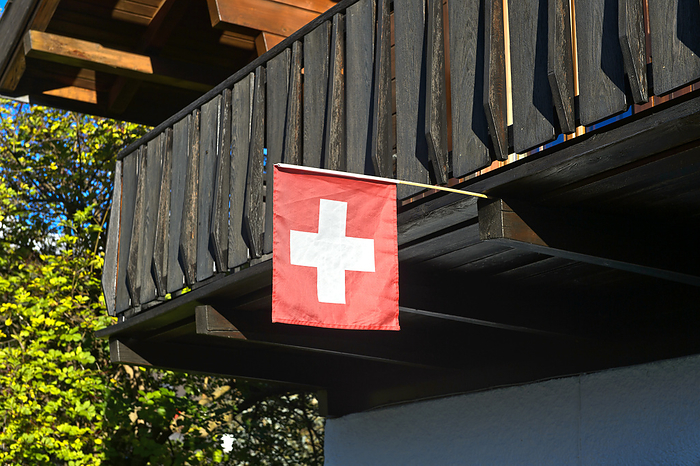 The Swiss flag flies on a chalet, Valais, Switzerland The Swiss flag flies on a chalet, Valais, Switzerland, by Zoonar Georg_A
