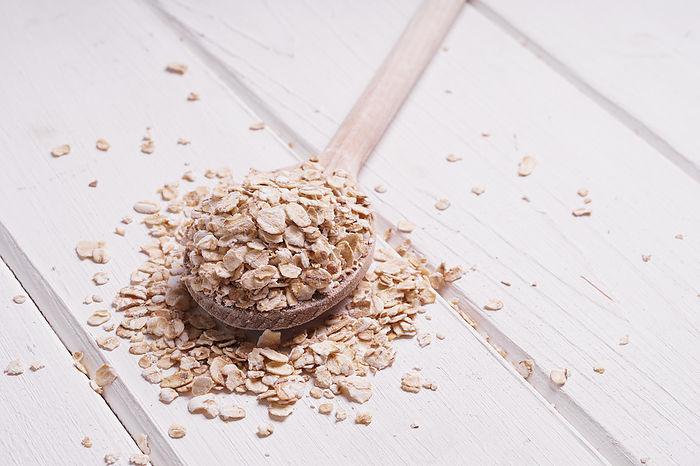 rolled oats oatmeal oat flakes on wooden spoon rolled oats oatmeal oat flakes on wooden spoon, by Zoonar Axel Bueckert