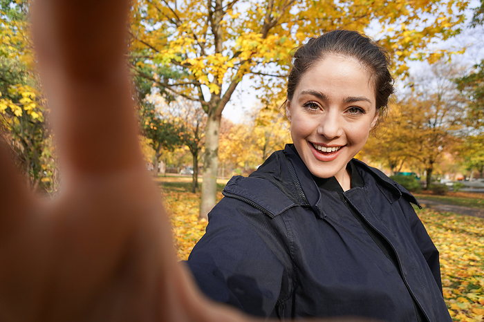 happy young woman taking selfie photo in park with autumn colors happy young woman taking selfie photo in park with autumn colors, by Zoonar Axel Bueckert