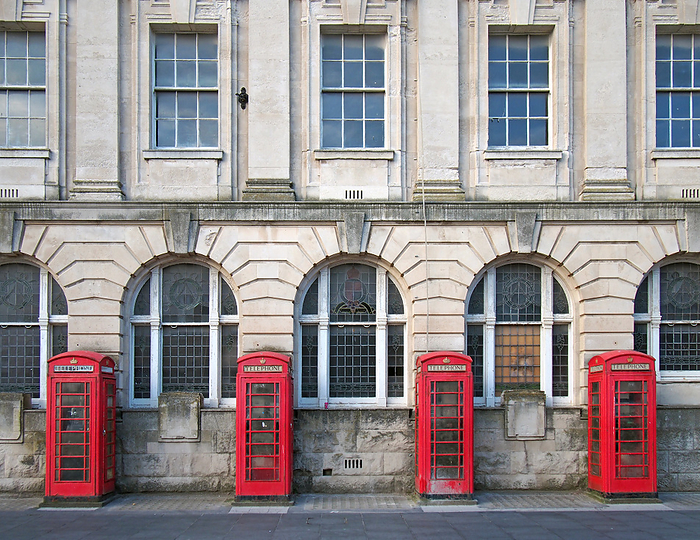 a line of four traditional british red phone boxes outside an old post office building in blackpool a line of four traditional british red phone boxes outside an old post office building in blackpool
