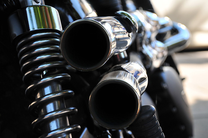 Close up rear view of a powerful classic black vintage motorcycle showing suspension and chrome exha Close up rear view of a powerful classic black vintage motorcycle showing suspension and chrome exha
